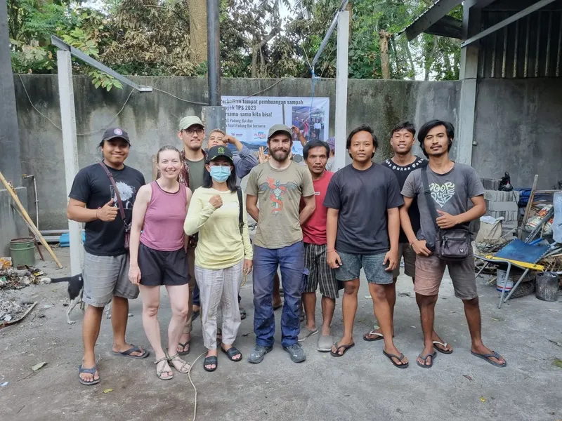 Groupe de personnes souriantes posant devant une banderole colorée
