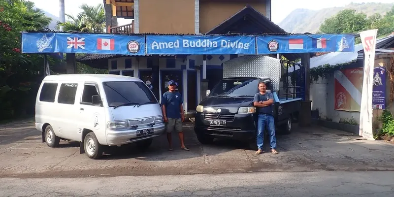 Devanture d'un centre de plongée avec deux hommes et des véhicules