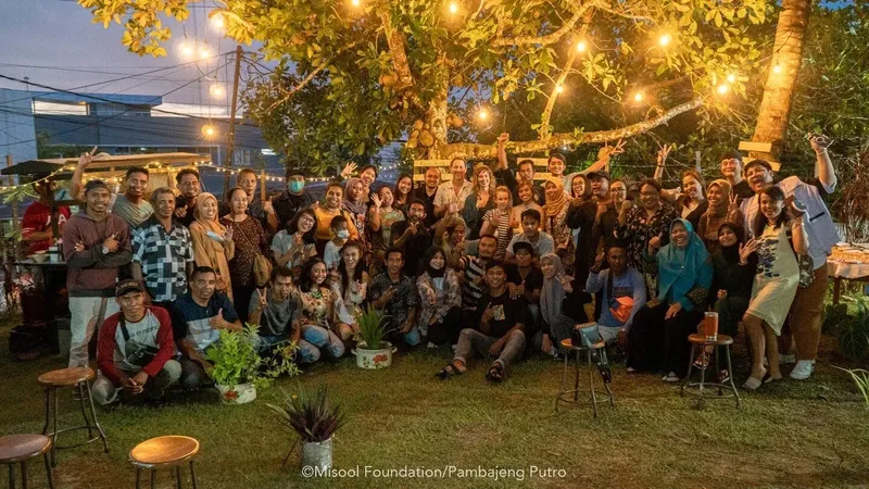 Groupe de personnes souriantes posant pour une photo en extérieur, ambiance festive