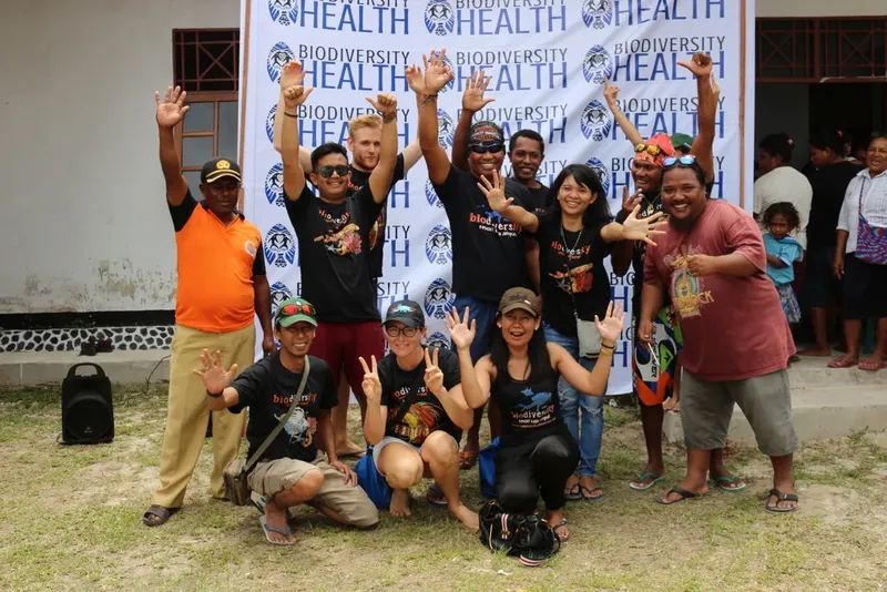 Groupe de personnes souriantes devant une bannière Biodiversity Health