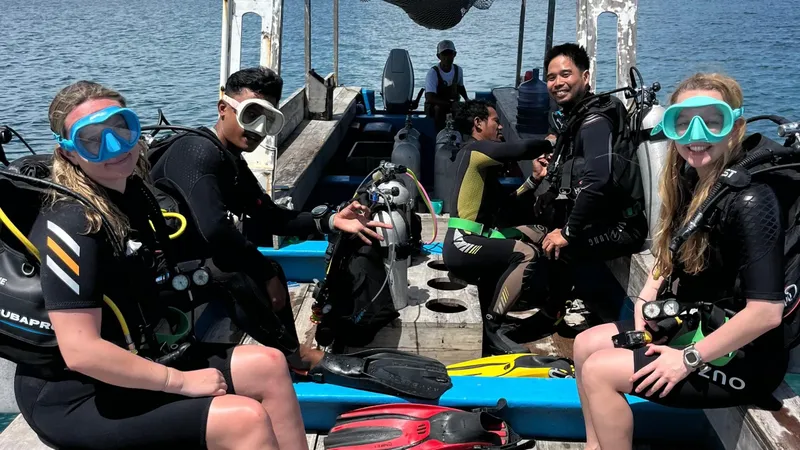 Groupe de plongeurs souriants sur un bateau de plongée en mer