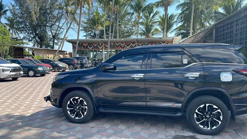 Parking avec plusieurs véhicules dont un SUV noir au premier plan