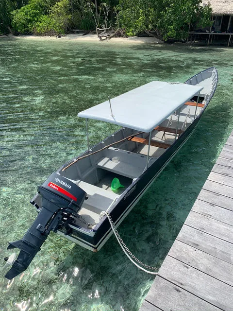 Bateau de plongée amarré à un ponton dans une eau turquoise claire