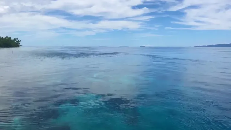 Vue mer dégagée avec un bateau au loin et ciel nuageux