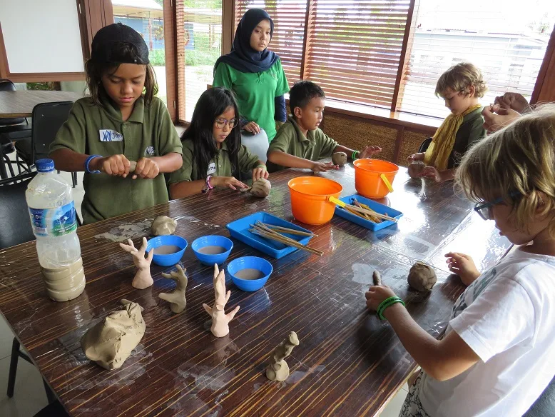 Groupe d'enfants modelant de la pâte à modeler autour d'une table