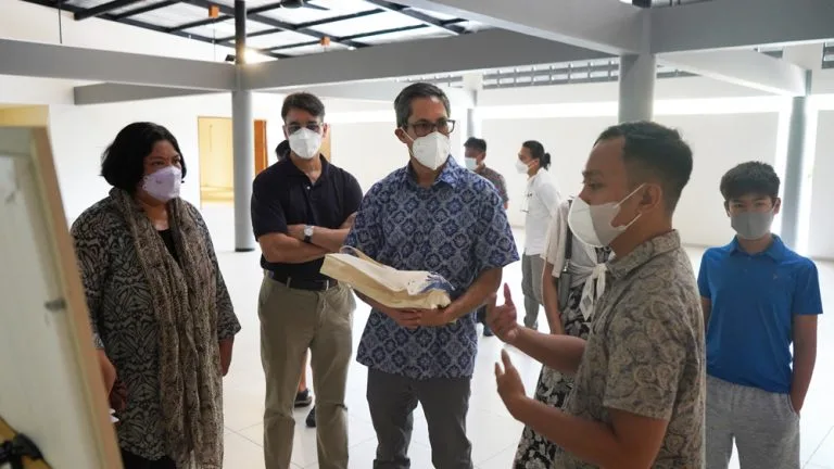 Groupe de personnes masquées regardant une présentation dans un espace intérieur