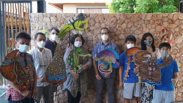 Groupe de personnes masquées posant avec des créatures marines en carton