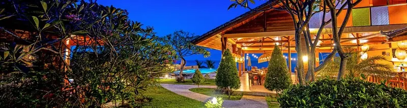 Terrasse d'un centre de plongée avec végétation luxuriante au crépuscule