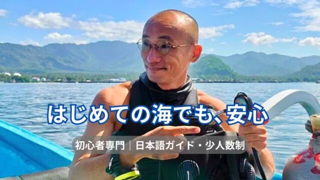 Homme en gilet de plongée, lunettes, pointant vers l'avant sur un bateau