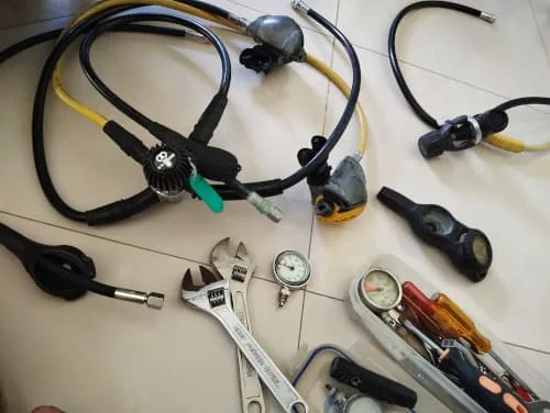 Equipement de plongée démonté, détendeurs, manomètre, lampe et outils