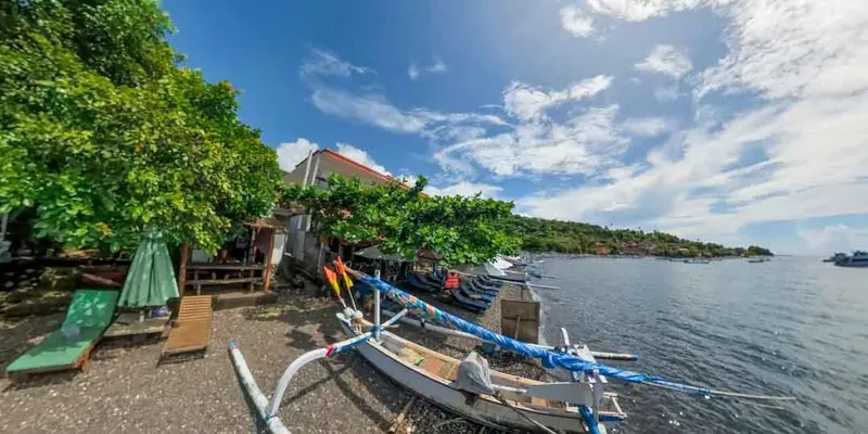 Bateau traditionnel amarré devant un centre de plongée en bord de mer