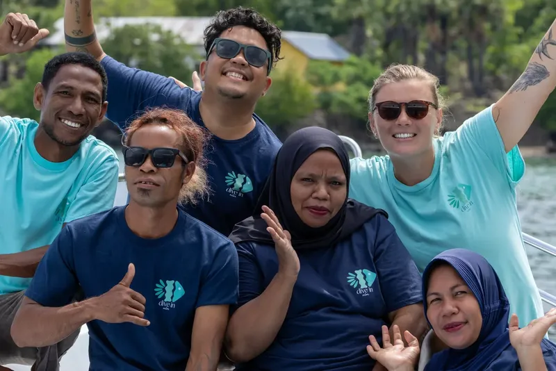 Groupe de personnes souriantes à bord d'un bateau de plongée