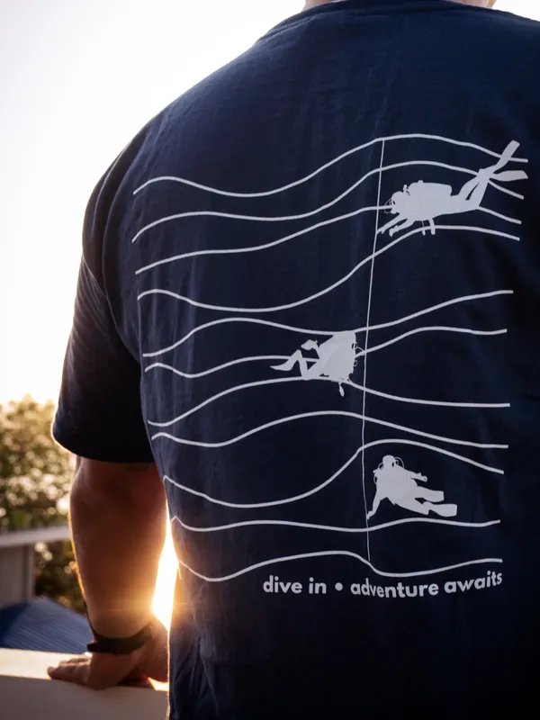 Dos d'une personne portant un t-shirt avec des motifs de plongée