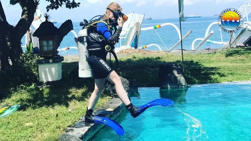 Plongeuse s'équipant au bord d'une piscine avec palmes et bouteille