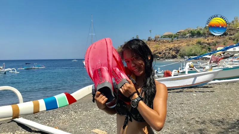 Plongeuse souriante tenant des palmes roses sur une plage ensoleillée