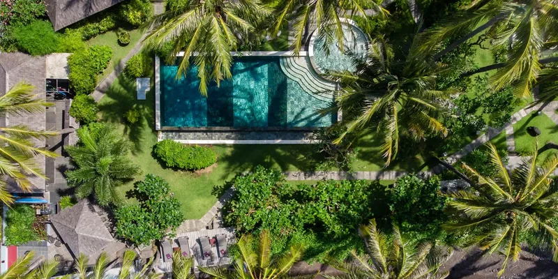 Piscine et végétation luxuriante vue d'en haut, ambiance tropicale relaxante