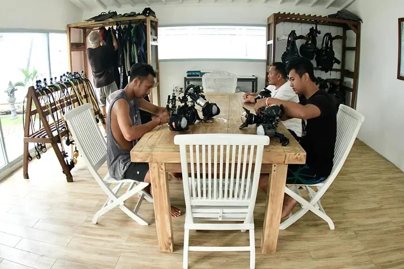 Des plongeurs assemblent leur équipement sur une table en bois