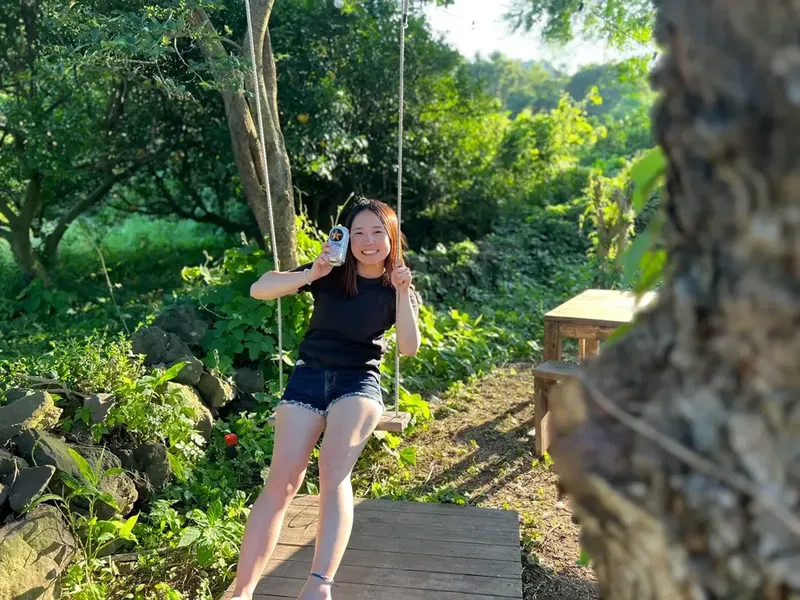 Jeune femme souriante se balance sur une balançoire en extérieur