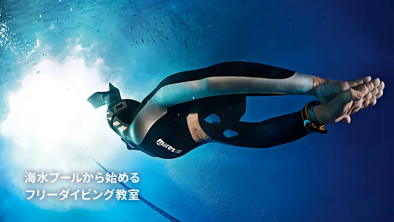 Plongeur en combinaison noire nageant dans une eau bleue claire