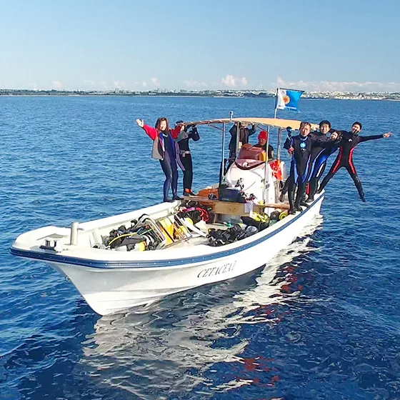 Groupe de plongeurs souriants sur un bateau en pleine mer