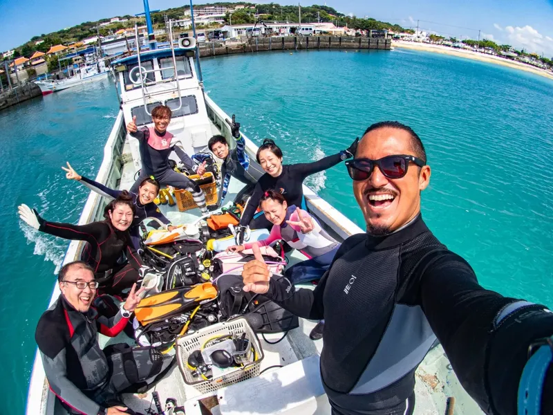 Groupe de plongeurs souriants sur un bateau en direction du site