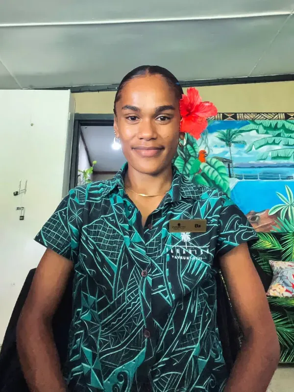 Portrait d'une personne souriante portant une chemise à motifs tropicaux