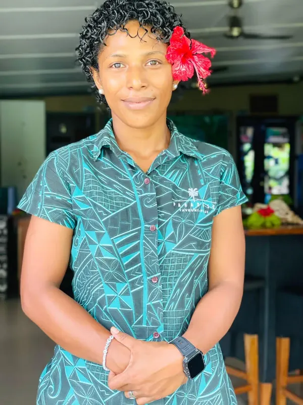 Portrait d'une femme souriante avec une fleur rouge dans les cheveux