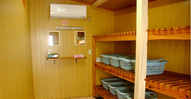 Intérieur d'un vestiaire avec étagères, climatisation et miroirs