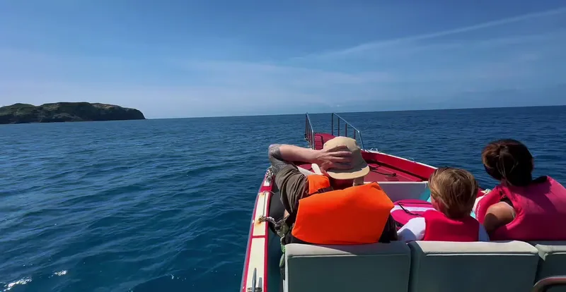Personnes à bord d'un bateau de plongée en direction d'une île
