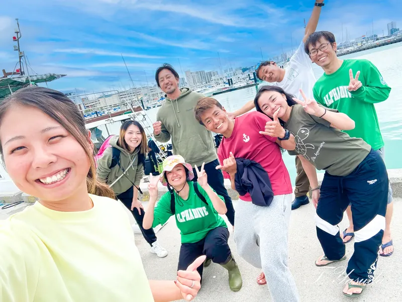 Groupe de personnes souriantes posant sur un quai ensoleillé