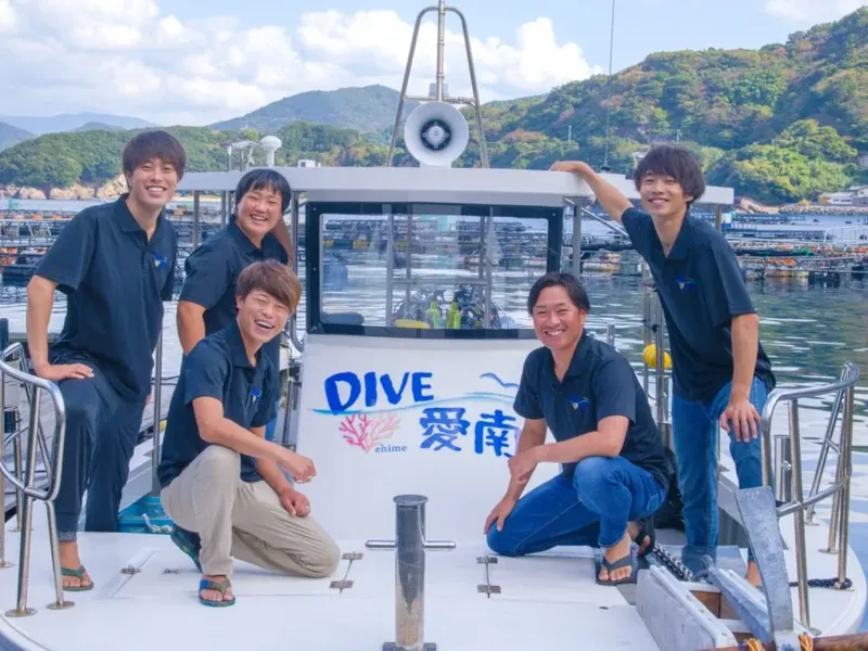 Equipe souriante sur un bateau de plongée avec l'inscription DIVE