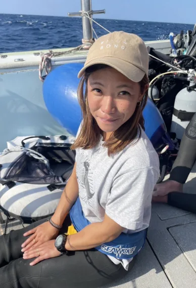 Jeune femme souriante sur un bateau de plongée en mer