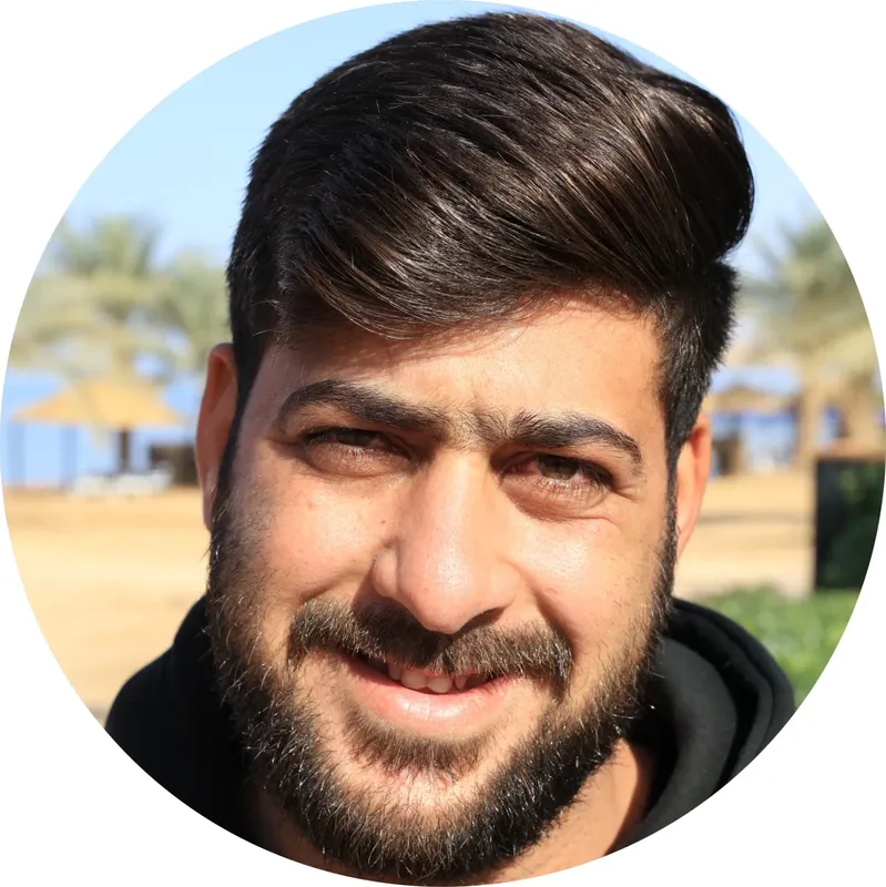 Portrait d'un homme souriant avec une barbe et des cheveux foncés
