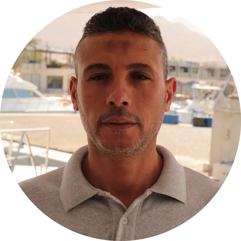 Portrait d'un homme devant des bateaux amarrés au port