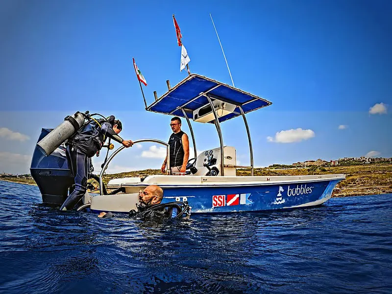 Plongeur s'apprête à entrer dans l'eau depuis un bateau de plongée