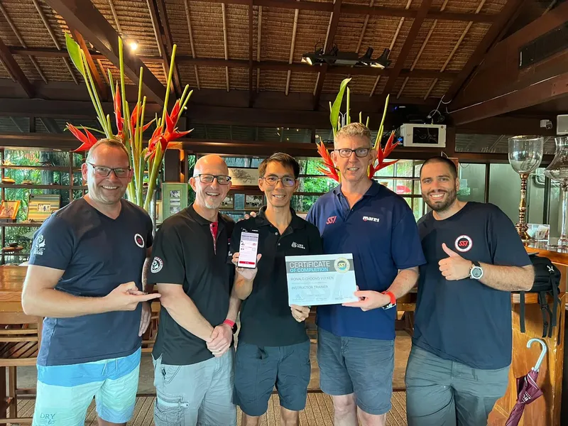 Groupe de personnes souriantes avec un certificat de formation plongée