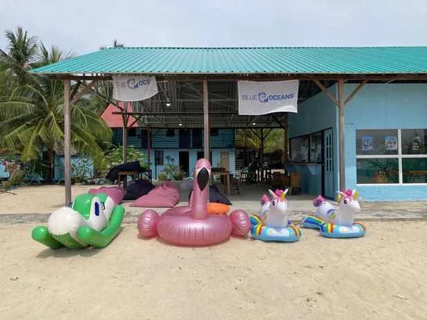 Façade d'un centre de plongée avec des bouées flottantes sur le sable