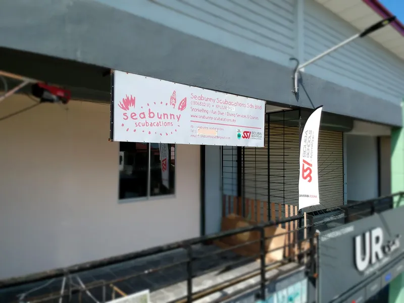 Façade d'un centre de plongée avec enseigne et drapeau publicitaire