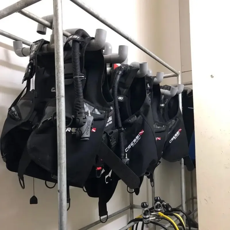 Equipements de plongée complets suspendus sur un étendoir métallique