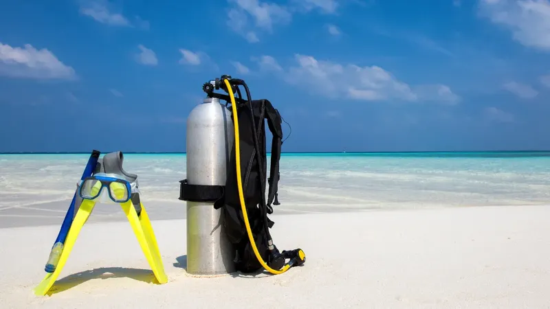Equipement de plongée sur une plage de sable blanc et eau turquoise