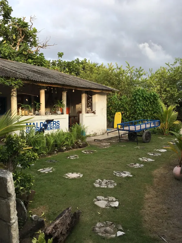 Façade d'un centre de plongée avec pelouse et végétation tropicale