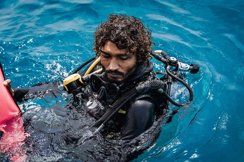 Plongeur avec équipement complet, préparant son immersion en mer