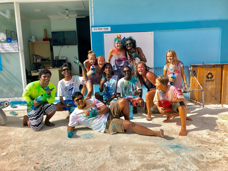Groupe de personnes souriantes couvertes de peinture colorée sur une plage