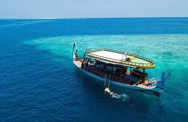 Bateau de plongée avec des personnes à bord et dans l'eau