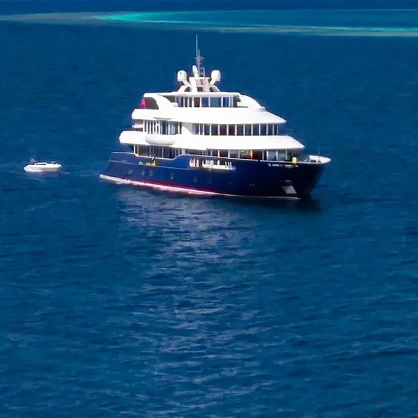 Grand bateau de croisière blanc et bleu navigue sur mer turquoise