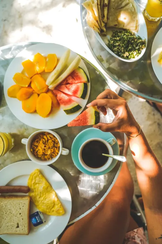 Petit déjeuner copieux avec fruits, céréales, omelette et café