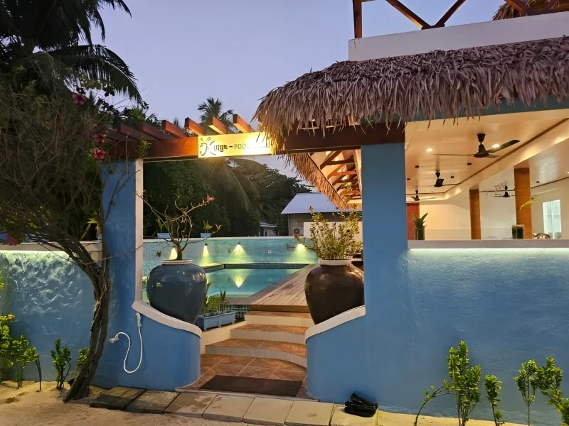 Entree d'un centre de plongee avec une piscine et vegetation tropicale