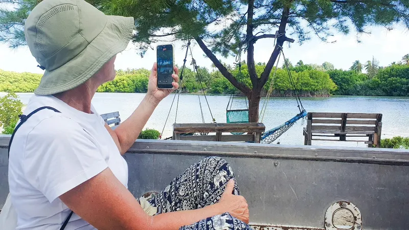 Femme prenant une photo avec un smartphone au bord de l'eau