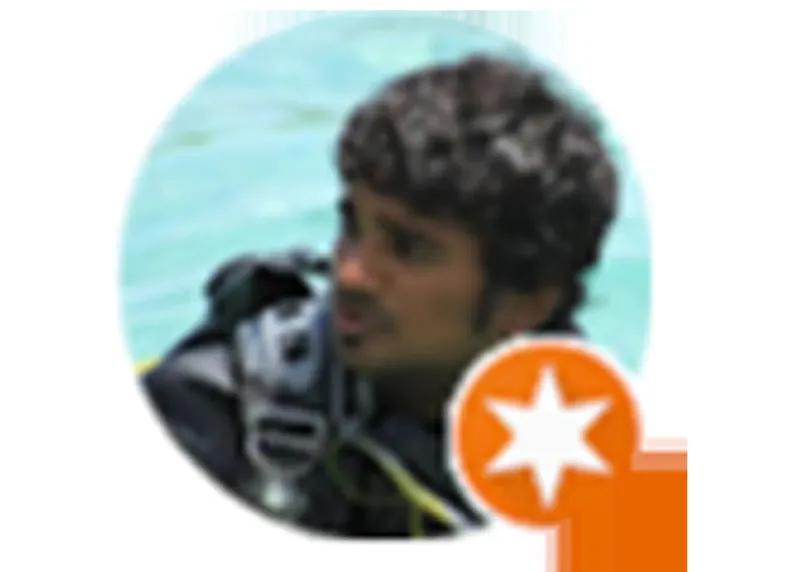 Plongeur avec combinaison et masque, regardant vers le spectateur sous l'eau