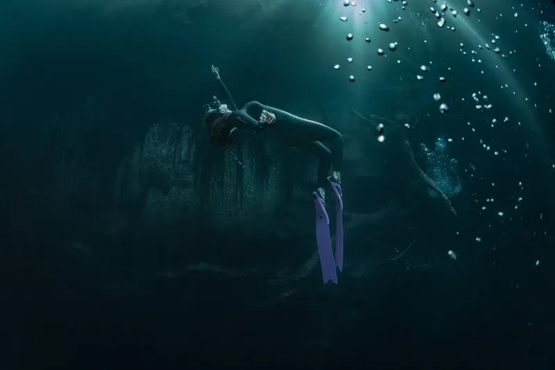 Apnée : une plongeuse évolue dans une eau sombre et profonde
